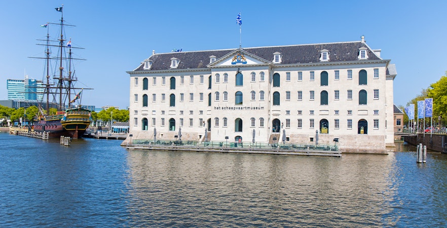 Amsterdam Maritime Museum with boats docked nearby, showcasing Dutch maritime history.