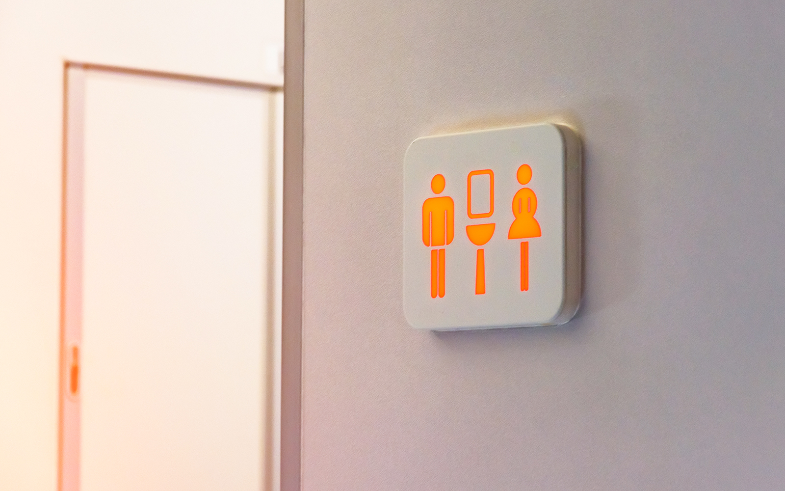 The busy toilet sign is marked in red, against the background is a door from the wc inside the train.