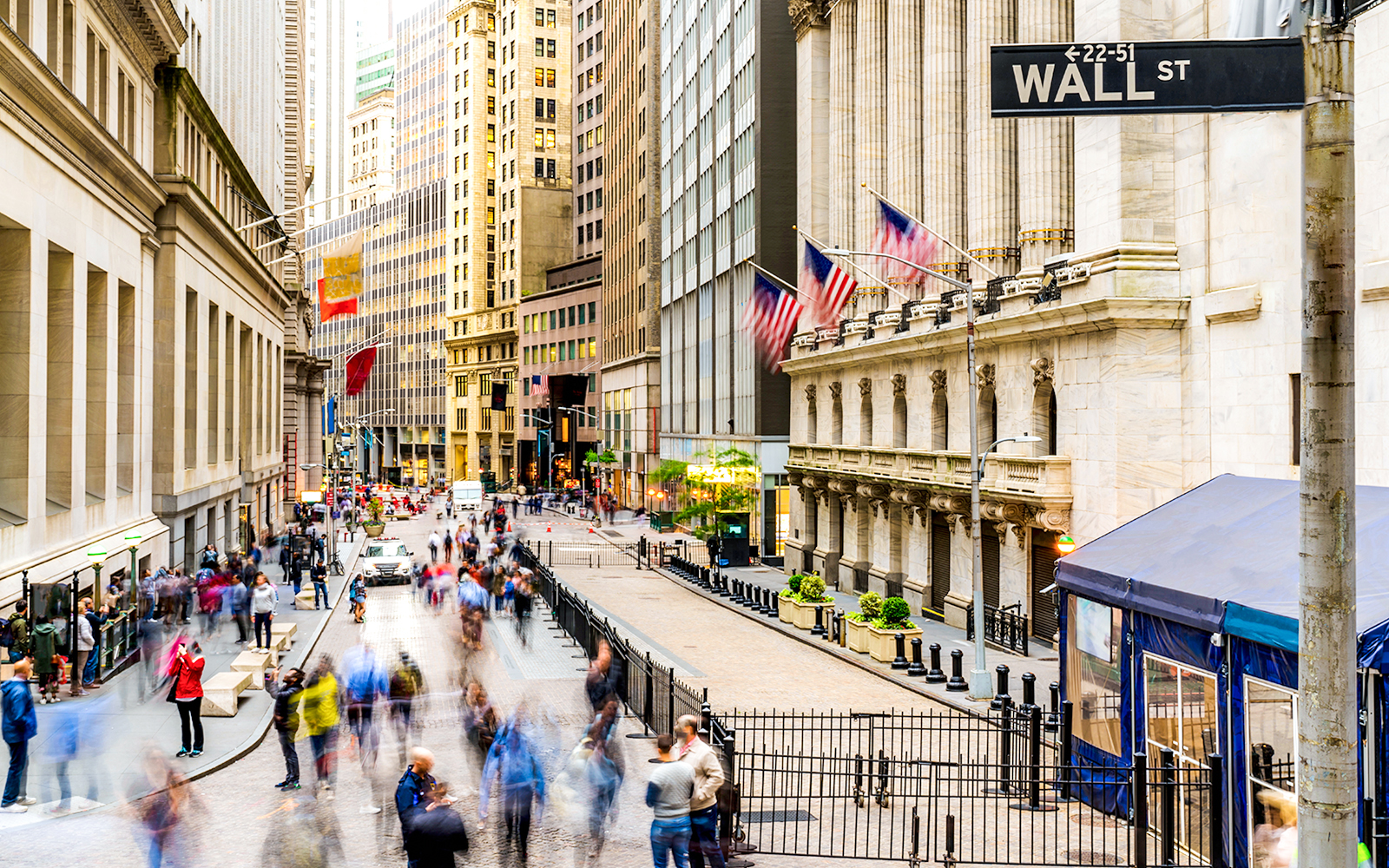 Crowd walking near New York Stock Exchange on Wall Street.