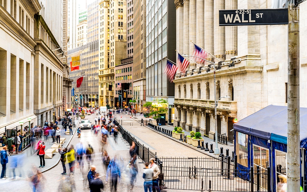 Crowd walking near New York Stock Exchange on Wall Street.