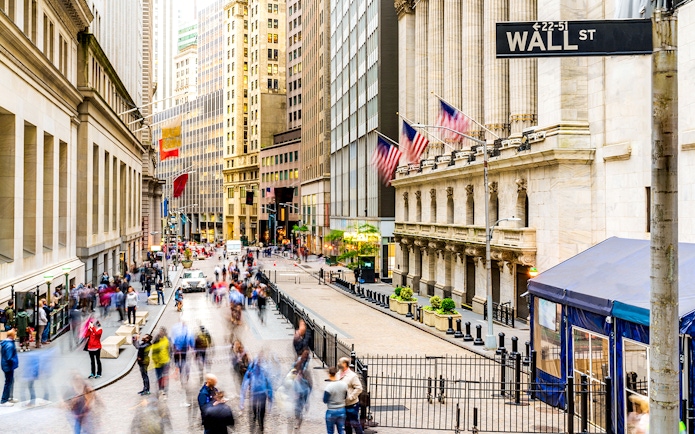 Crowd walking near New York Stock Exchange on Wall Street.