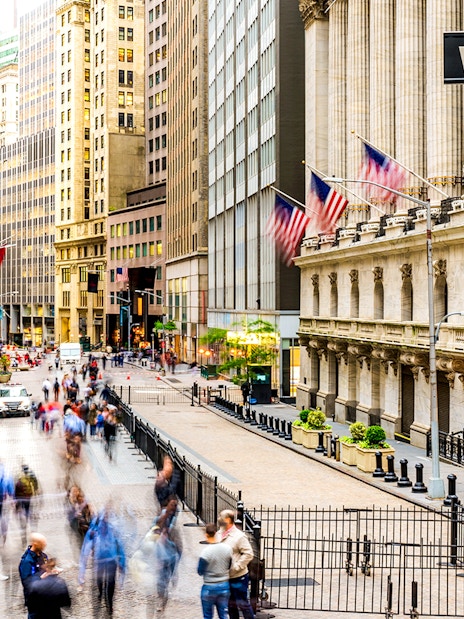 Crowd walking near New York Stock Exchange on Wall Street.