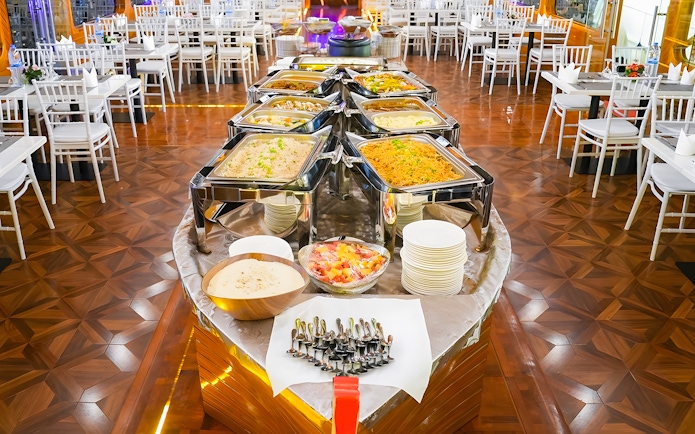 Buffet setup on a dhow cruise in Dubai Marina with various dishes and dining tables.