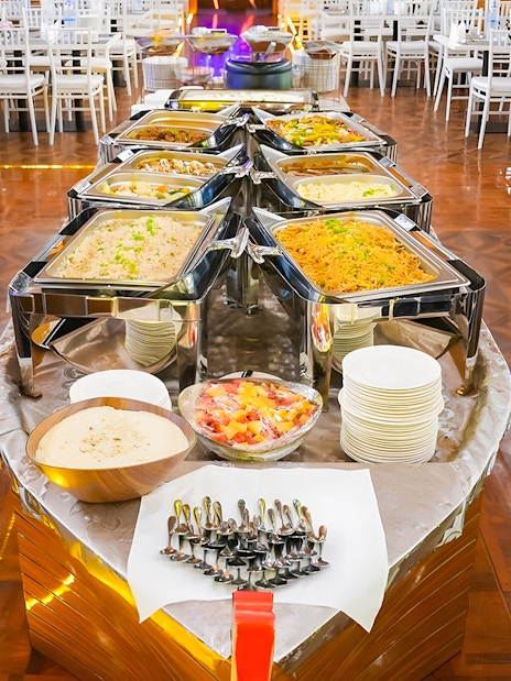 Buffet setup on a dhow cruise in Dubai Marina with various dishes and dining tables.