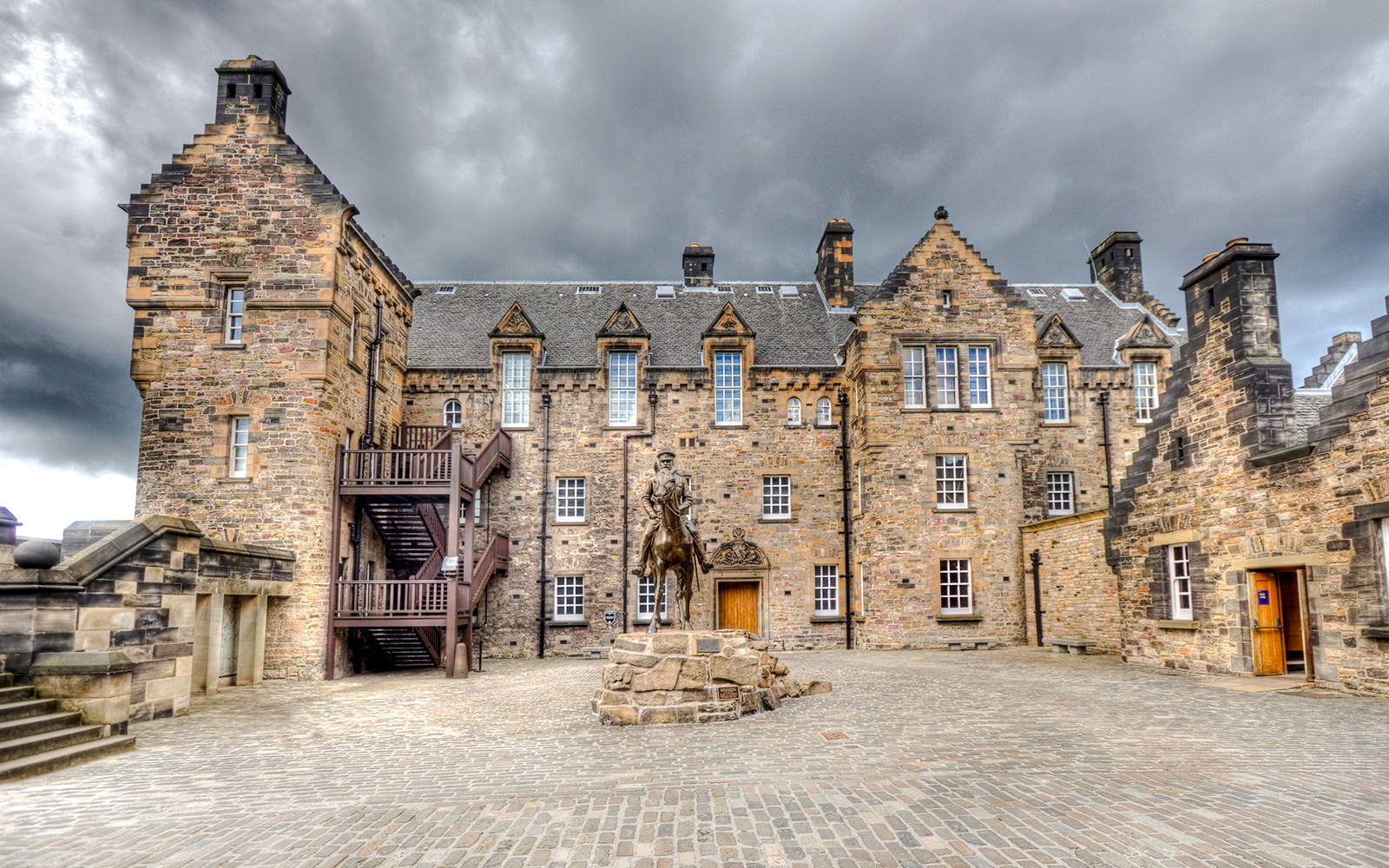 Edinburgh Castle Esplanade with historic stone buildings and equestrian statue.