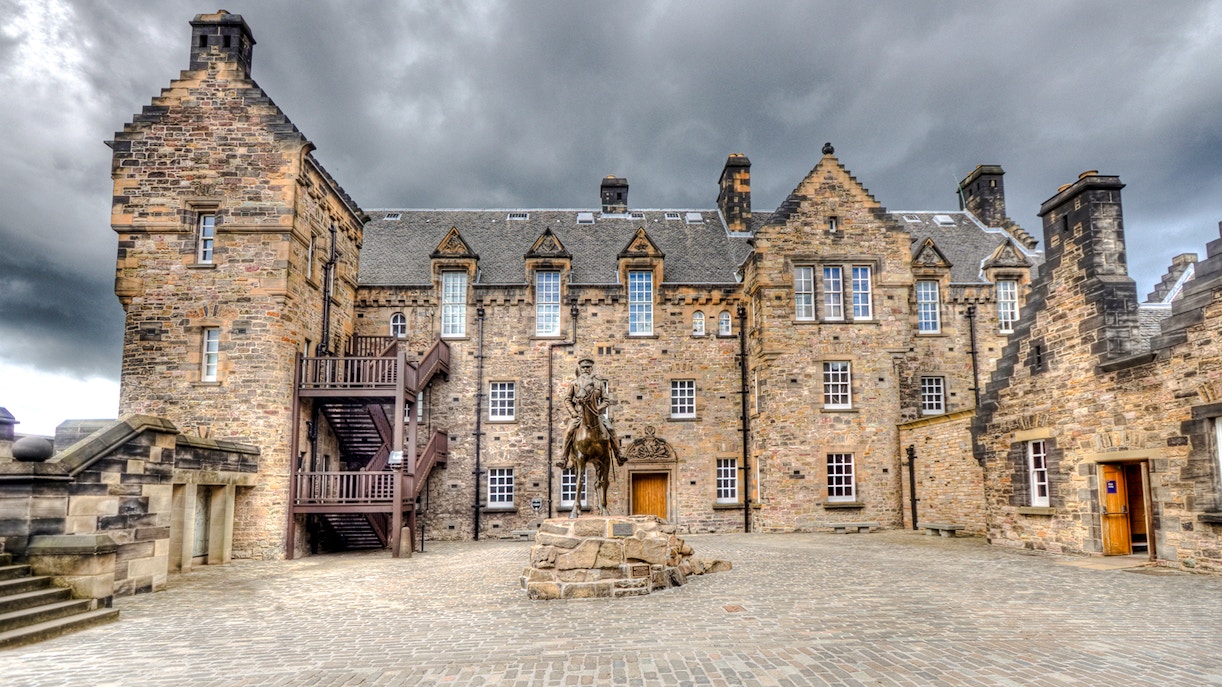 Edinburgh Castle Esplanade with historic stone buildings and equestrian statue.