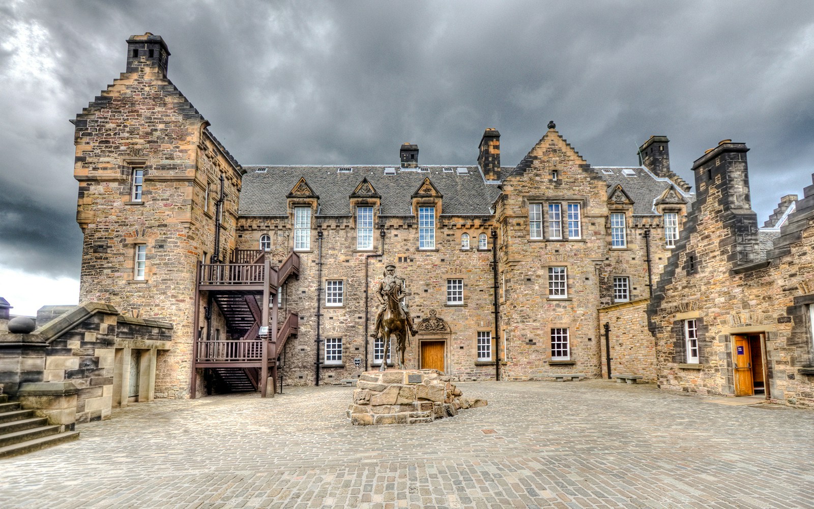 Edinburgh Castle Esplanade with historic stone buildings and equestrian statue.