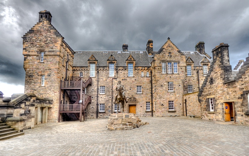 Edinburgh Castle Esplanade with historic stone buildings and equestrian statue.