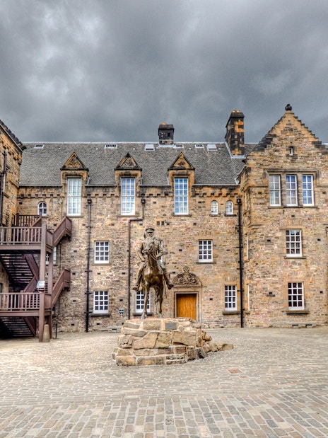 Edinburgh Castle Esplanade with historic stone buildings and equestrian statue.