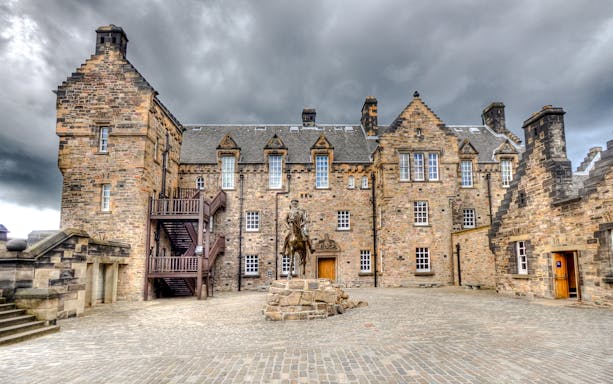 Edinburgh Castle Esplanade with historic stone buildings and equestrian statue.