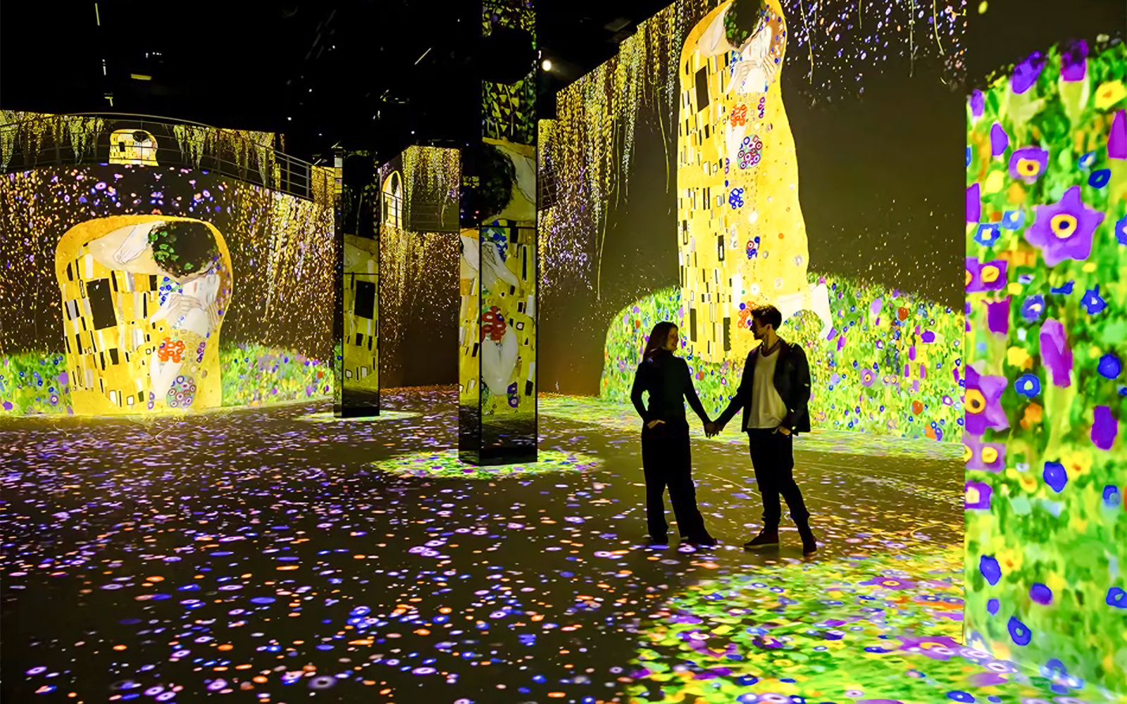 Gustav Klimt digital art display at Port des Lumières, Hamburg, with visitors exploring.