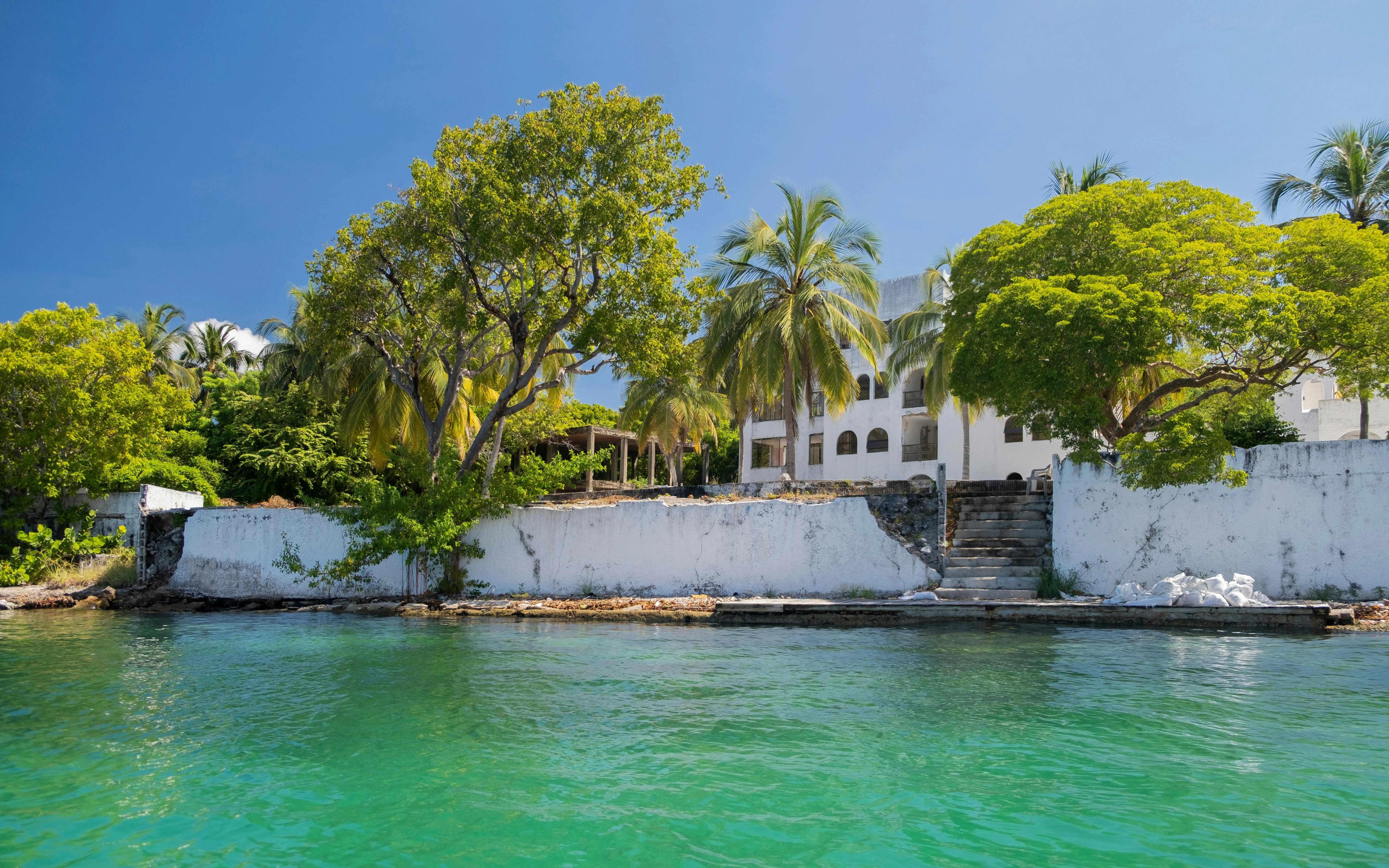 Old abandoned villa of Pablo Escobar surrounded by trees on Isla Grande, Cartagena, Colombia.
