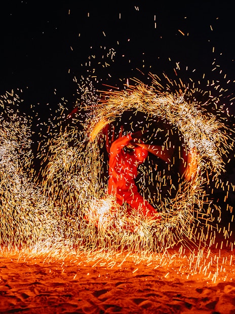 Performer spinning fire in a desert show, Dubai.