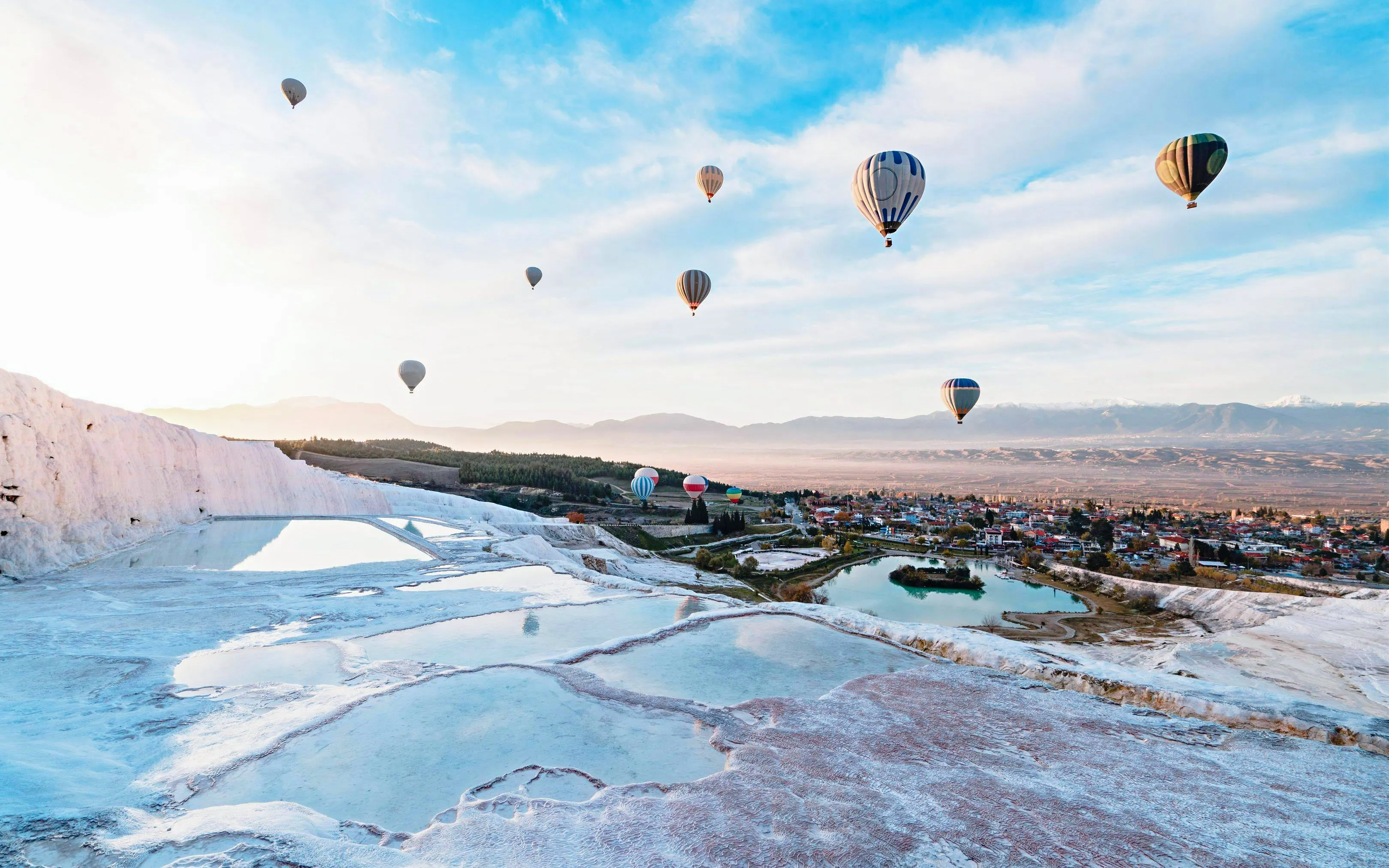 Hot air balloons over Pamukkale's travertine terraces, Turkey.