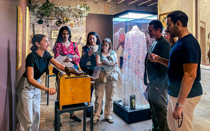 Visitors observing flamenco artifacts at Tablao Casa de la Memoria in Seville.