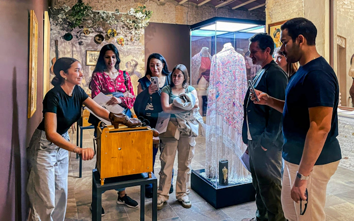 Visitors observing flamenco artifacts at Tablao Casa de la Memoria in Seville.