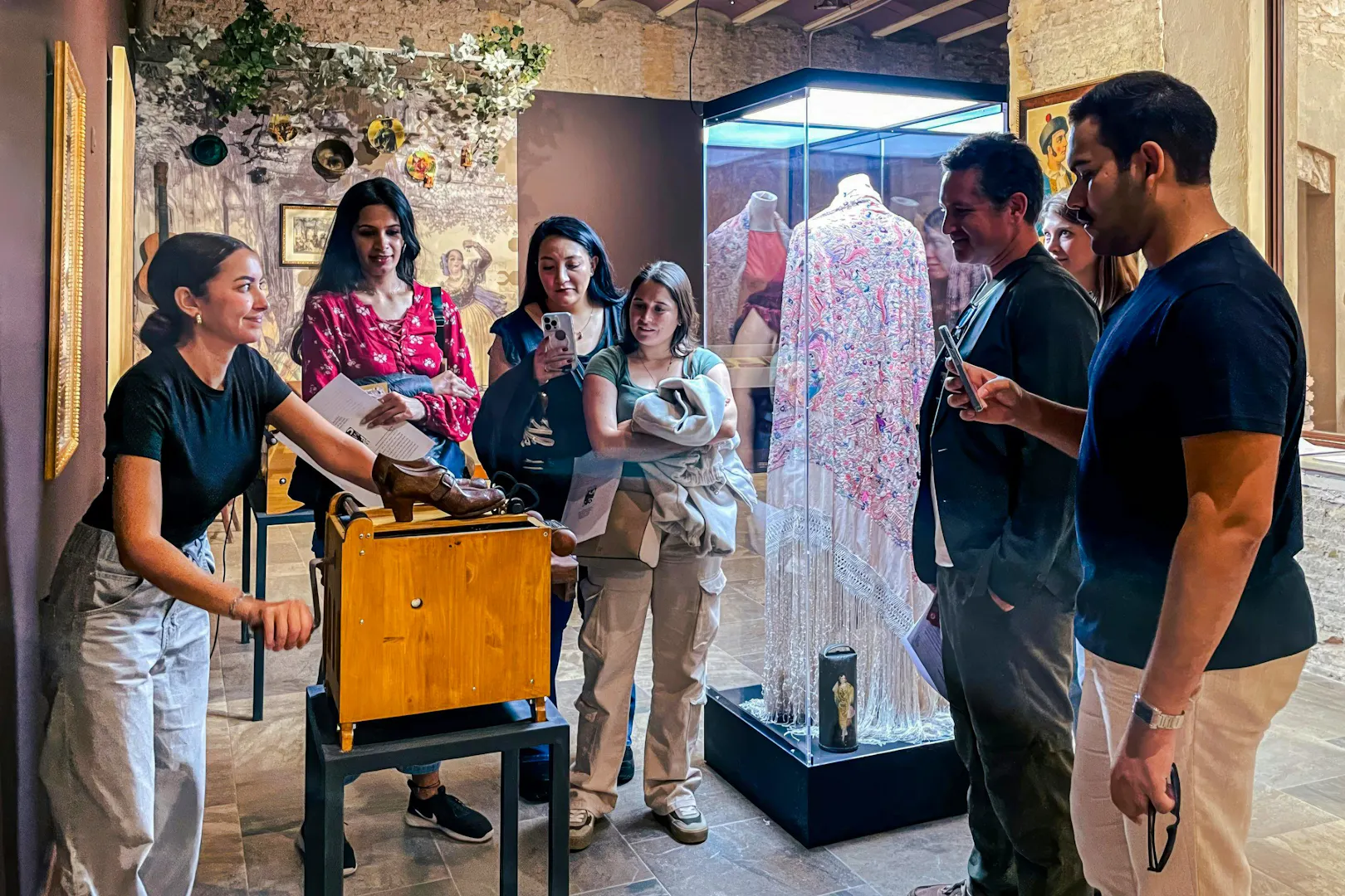 Visitors observing flamenco artifacts at Tablao Casa de la Memoria in Seville.