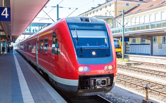 Red train at Munich station platform, part of Munich City Pass with public transportation.