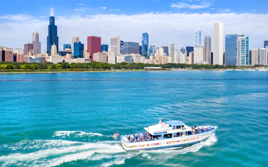 Sightseeing cruise boat on Chicago River with city skyline in background.
