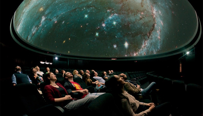Visitors watching a starry sky projection inside the Royal Observatory Planetarium.