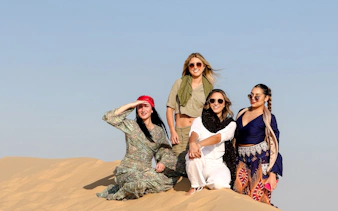 Group enjoying Abu Dhabi desert safari on sand dunes.