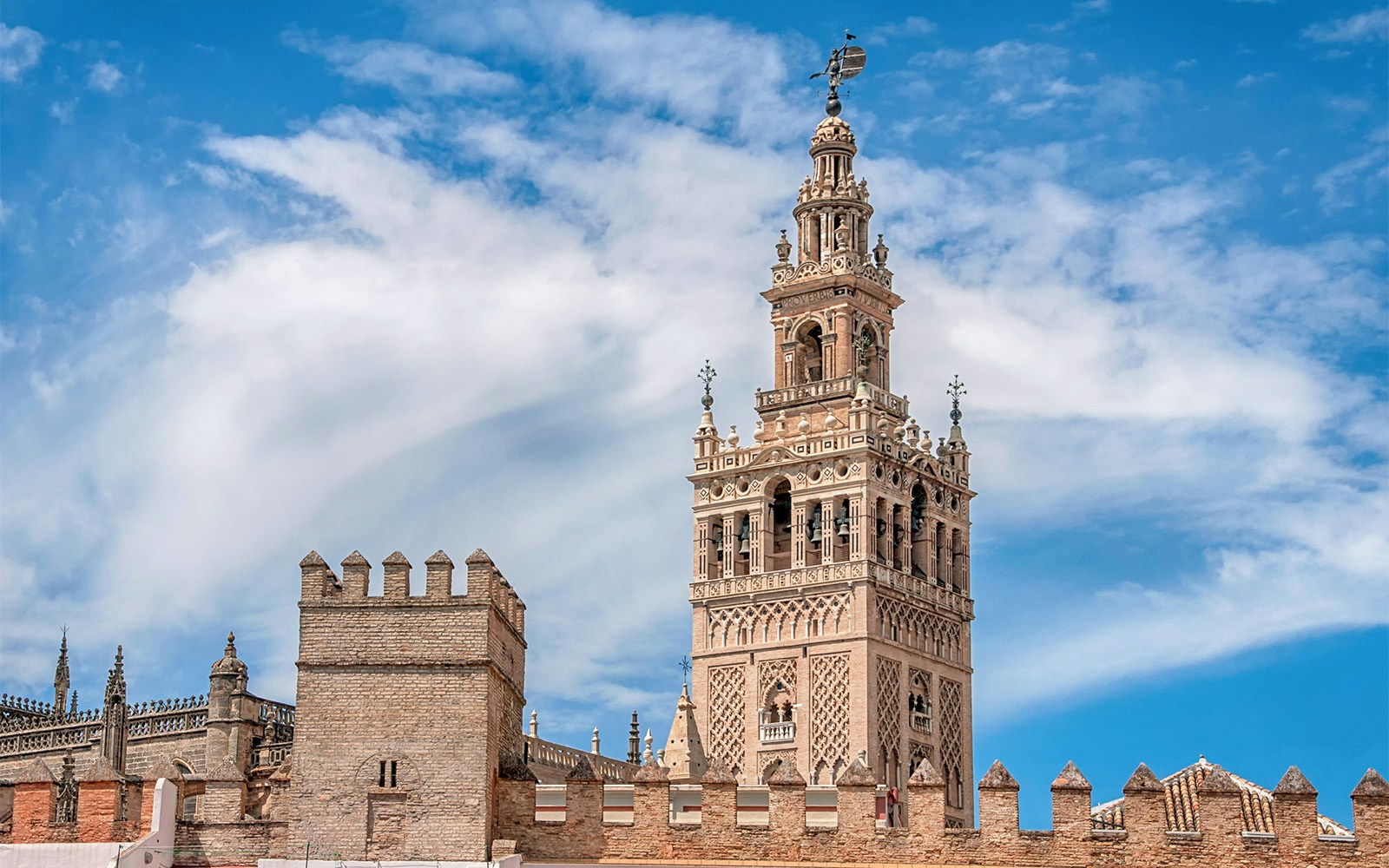 Seville Cathedral's La Giralda tower under a blue sky.