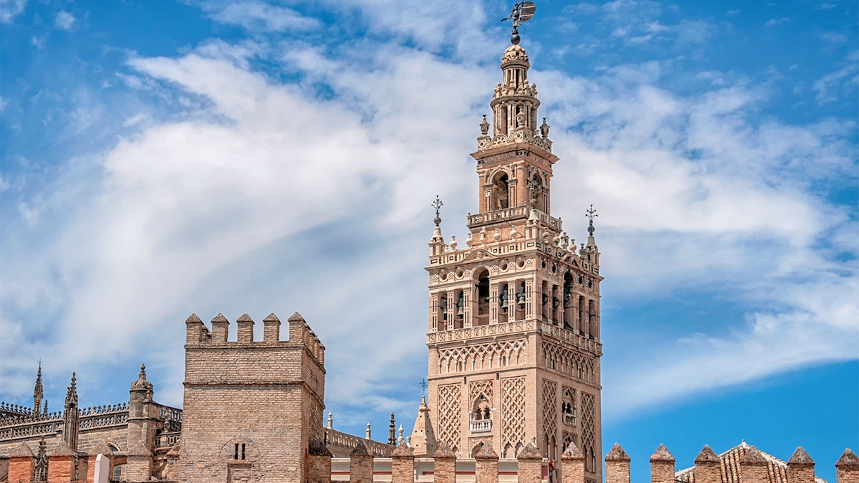 La Giralda bell tower of Seville Cathedral against a clear blue sky.