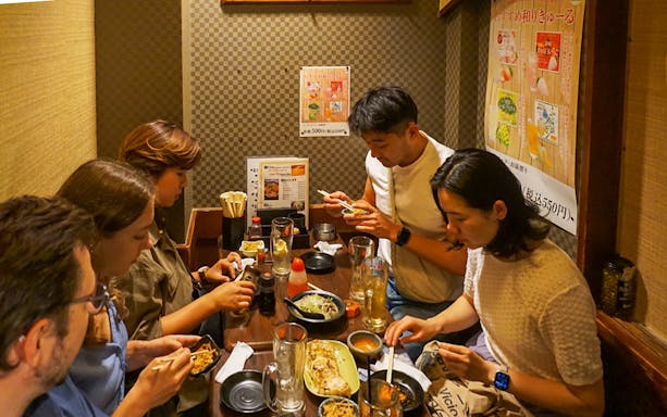 Group dining at a cozy Shinjuku restaurant during a night out experience.