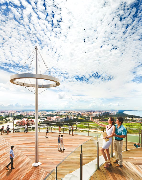 Visitors enjoying the view from Marina Bay Sands Sky Park in Singapore.