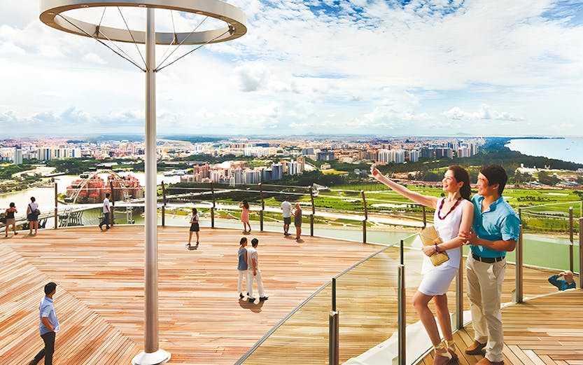 Visitors enjoying the view from Marina Bay Sands Sky Park in Singapore.
