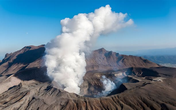 Aso Volcano emitting smoke in Kyushu, Japan, part of the Kumamoto Castle and Kurokawa Onsen tour.
