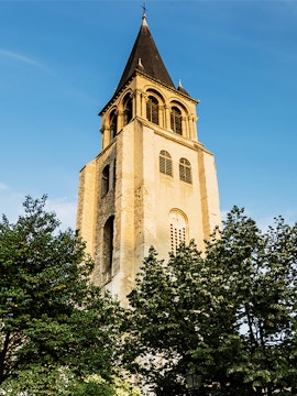 Saint Germain des Prés church tower against blue sky in Paris.
