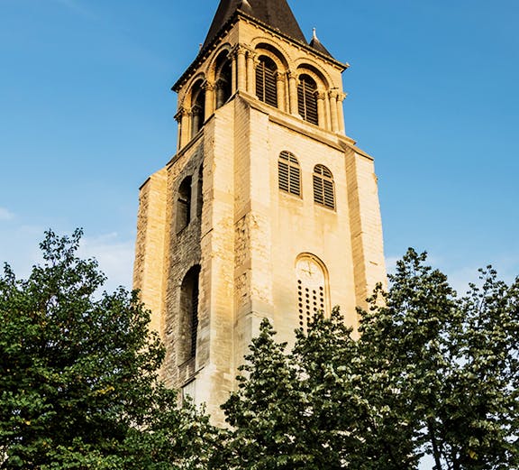 Saint Germain des Prés church tower against blue sky in Paris.