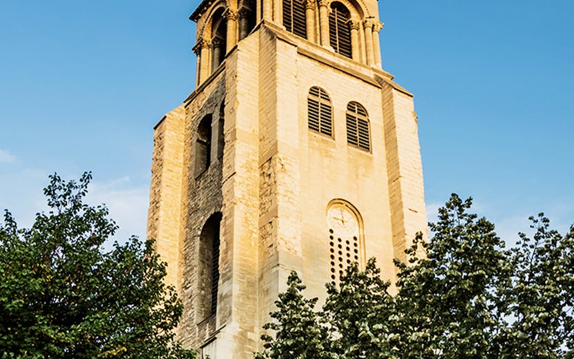 Saint Germain des Prés church tower against blue sky in Paris.