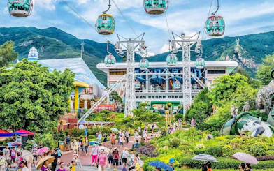 Cable cars above Ocean Park Hong Kong with lush greenery and visitors below.