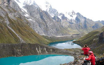 Trekking group overlooking turquoise lakes in Huayhuash, Cusco.