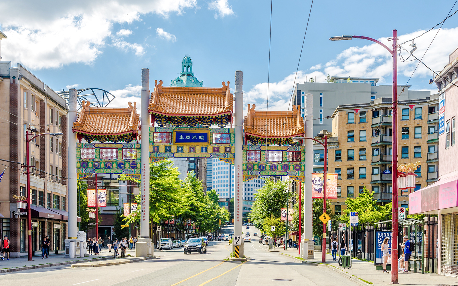 Chinatown Millennium Gate on Pender Street, Vancouver, with surrounding buildings and pedestrians.