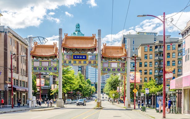 Chinatown Millennium Gate on Pender Street, Vancouver, with surrounding buildings and pedestrians.