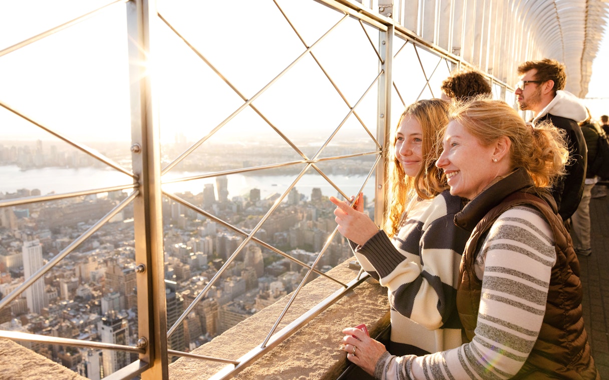 Visitors enjoying the view from the Empire State Building observation deck in New York City.