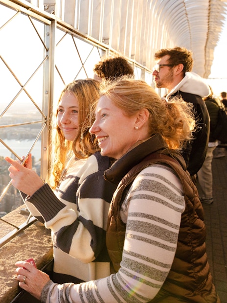Visitors enjoying the view from the Empire State Building observation deck in New York City.