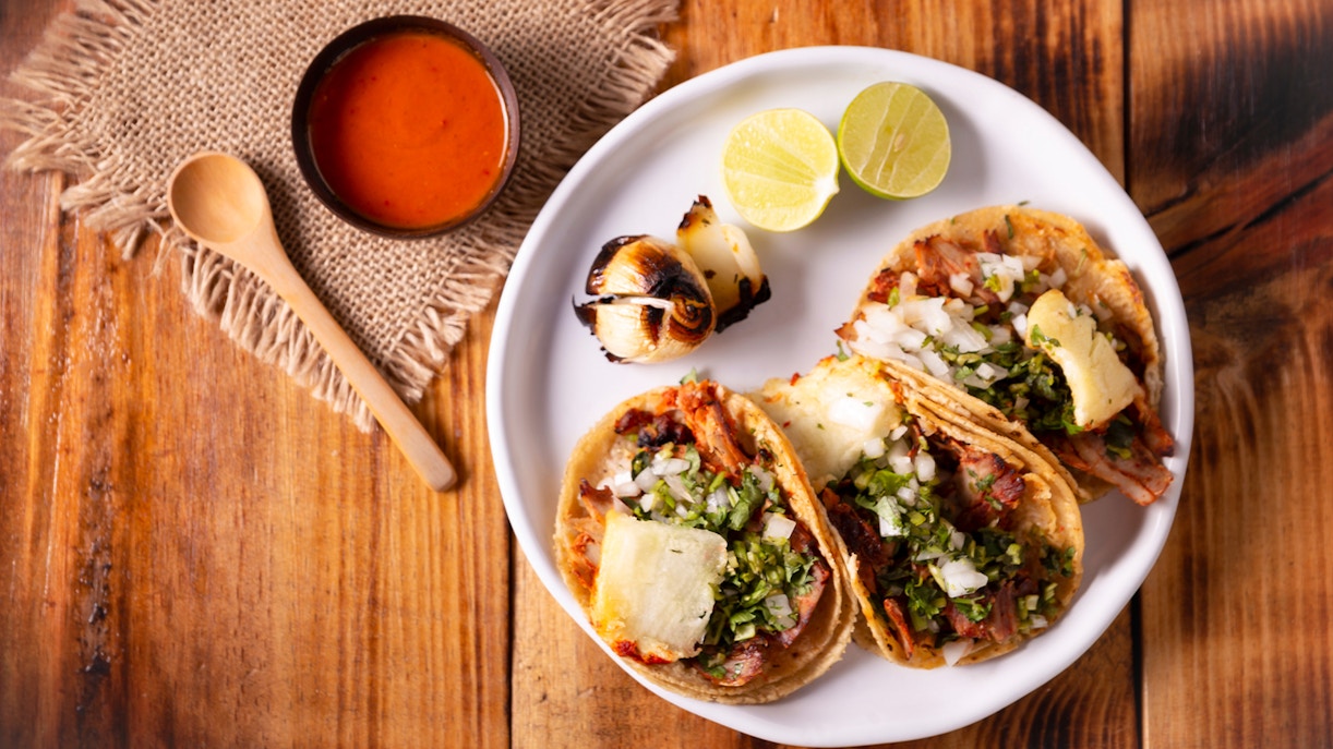 Tacos El Pastor with pineapple and cilantro on a plate, Mexican cuisine.