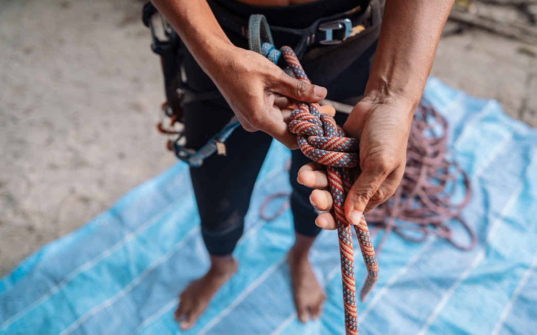 Climber tying a knot during Krabi rock climbing course at Railay.