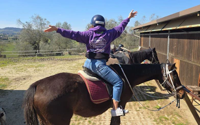 Horseback rider enjoying Tuscany countryside during Chianti winery tour.