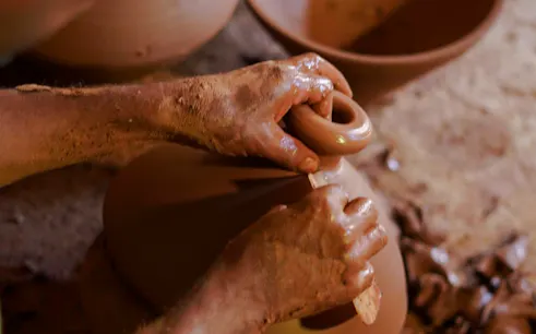 Hands shaping clay pottery during a workshop near Amizmiz, Marrakesh.