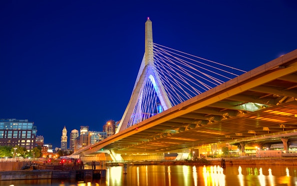 Zakim Bunker Hill Bridge illuminated at night, viewed from a Boston harbor cruise.