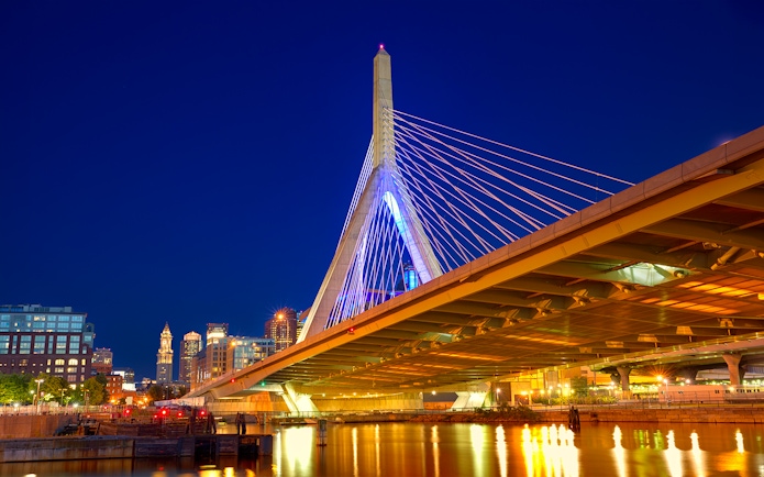 Zakim Bunker Hill Bridge illuminated at night, viewed from a Boston harbor cruise.