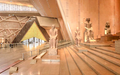 Grand Egyptian Museum interior with ancient statues and architectural design.