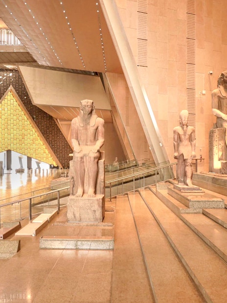 Grand Egyptian Museum interior with ancient statues and architectural design.
