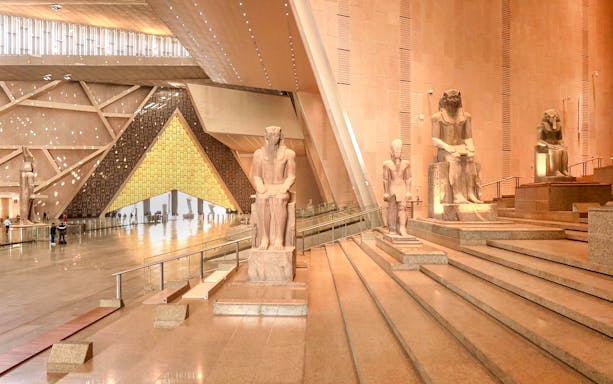 Grand Egyptian Museum interior with ancient statues and architectural design.