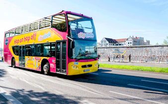 City Circle bus passing by the Berlin Wall with colorful murals.
